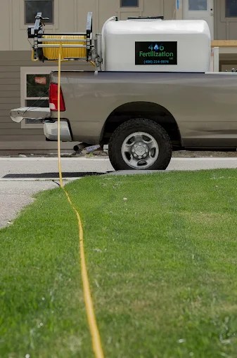Brown truck with a white tank in the back that says 406 Fertilization